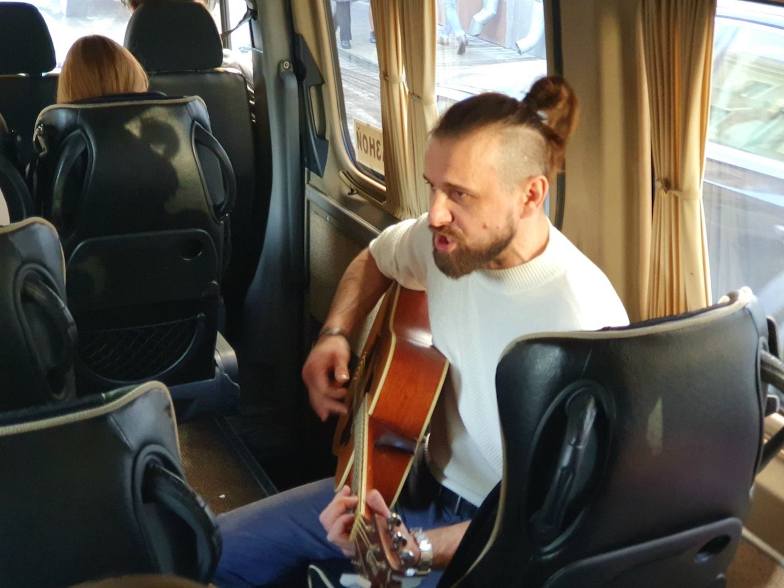 Бард Роман Парфенов исполняет песни в рамках автобусной версии экскурсии 