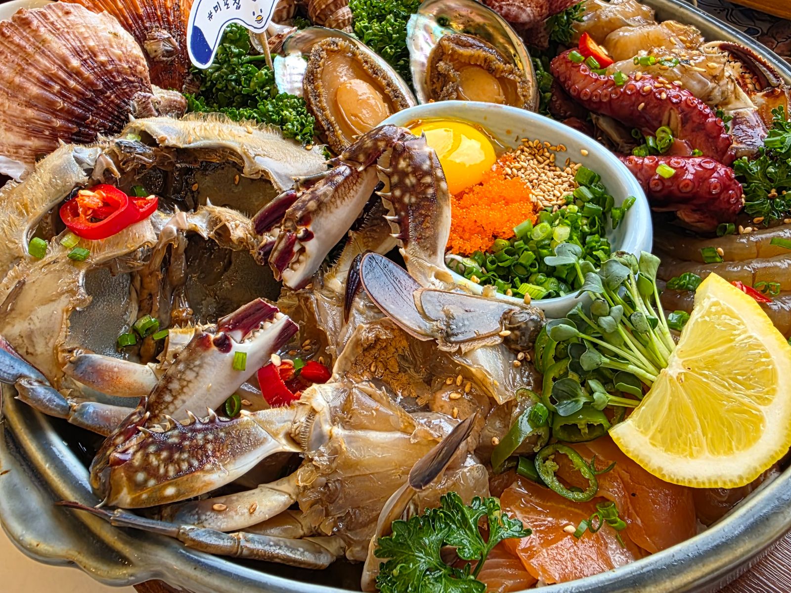 🥢 Ассорти из морепродуктов (해산물 모둠회) — эффектное корейское блюдо с крабом в соевом маринаде, гребешками, осьминогом, абалоном, лососем, икрой и желтком. Подаётся с зеленью, лимоном и специями.
Яркий вкус моря в каждой детали!