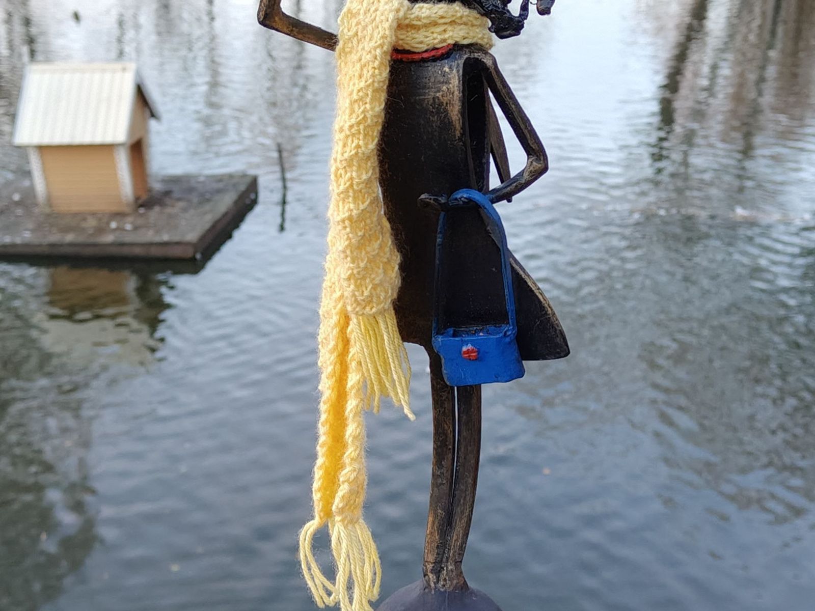 Ангел со смартфоном и сумочкой на пруду