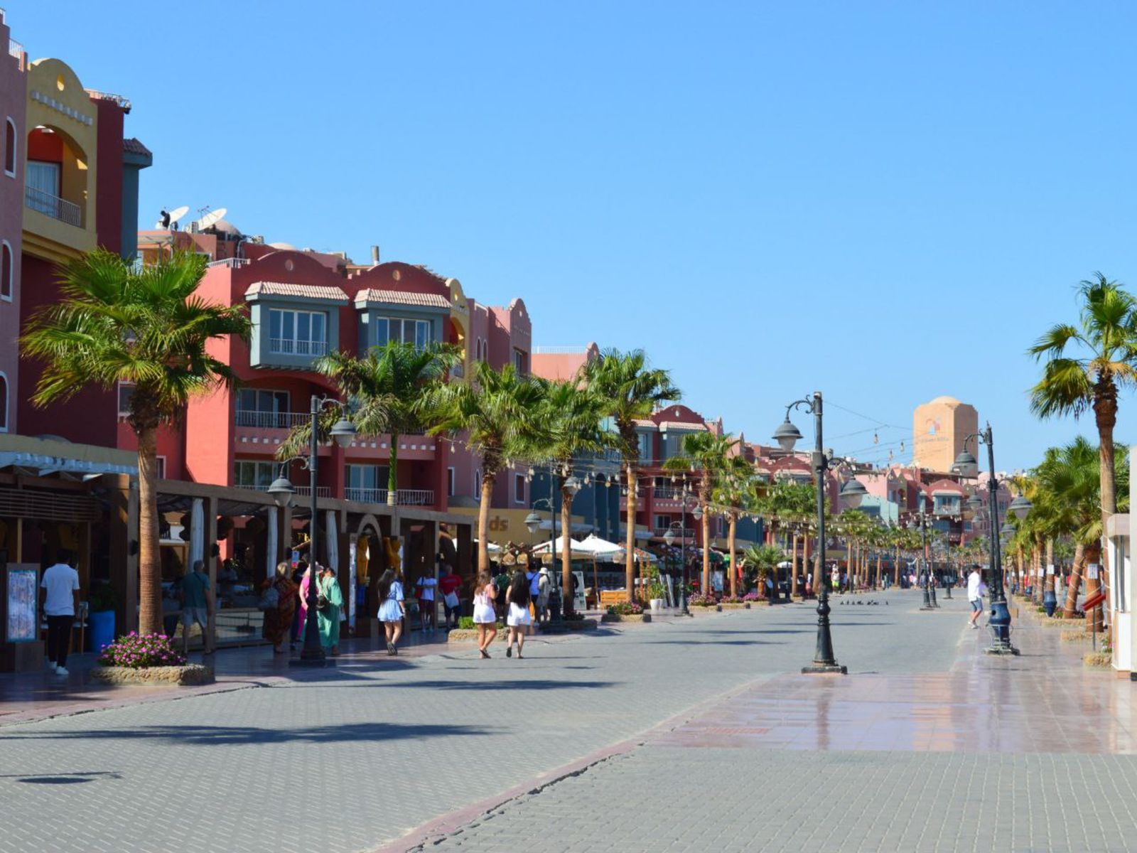 Центральная набережная Хургады с прогулочной зоной, пальмами и городскими зданиями 