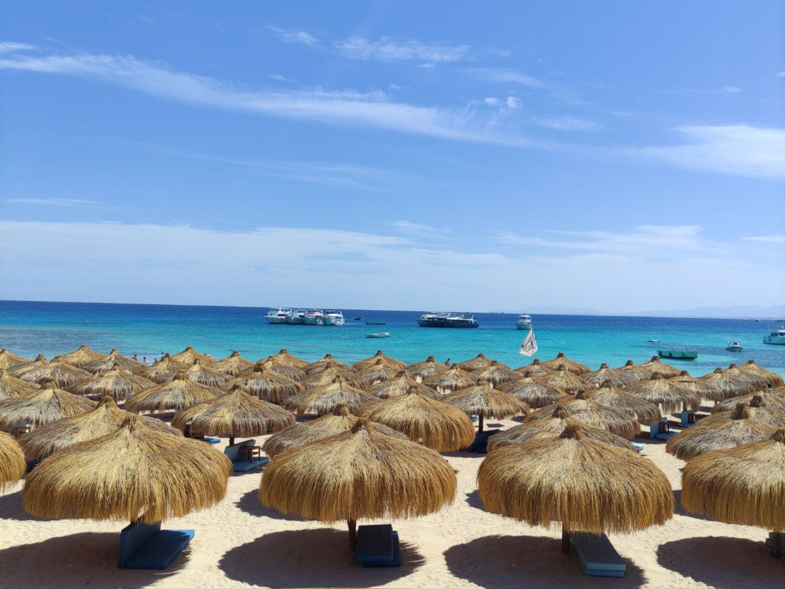 Оборудованный пляж острова Эден с соломенными зонтами и видом на Красное море 