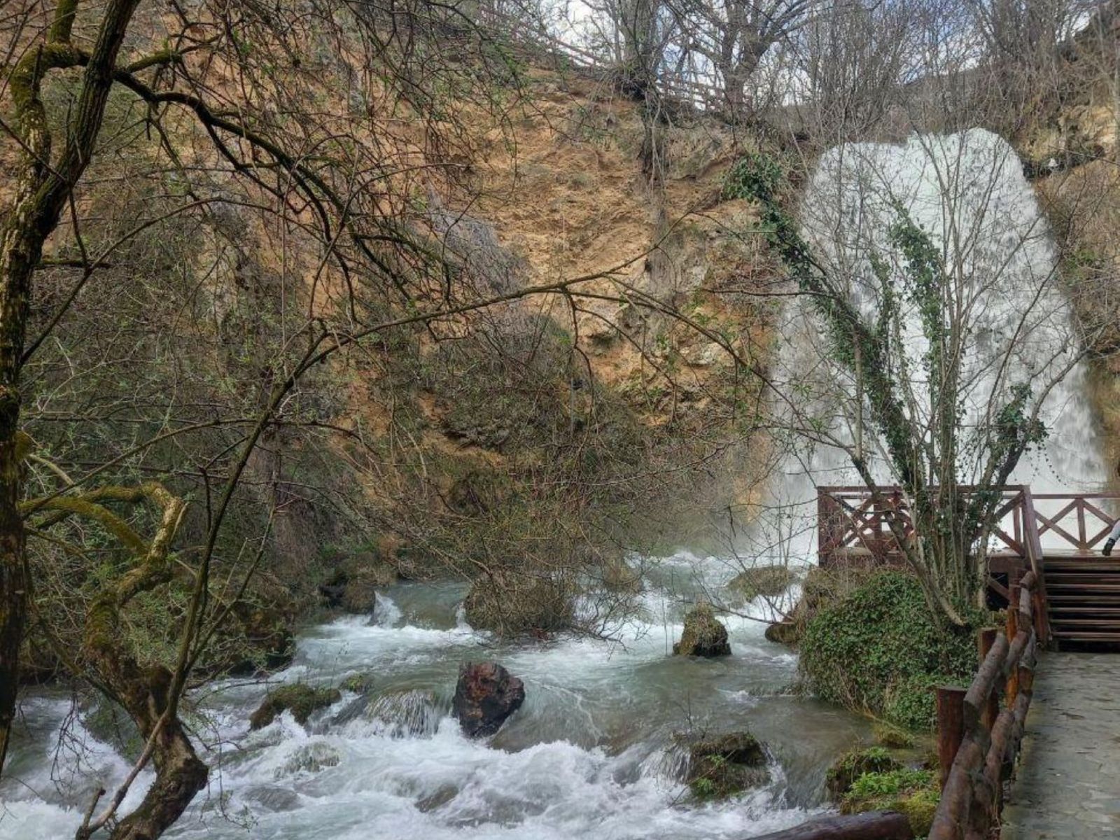 Живописный водопад с каскадами воды и зелёными скалами.