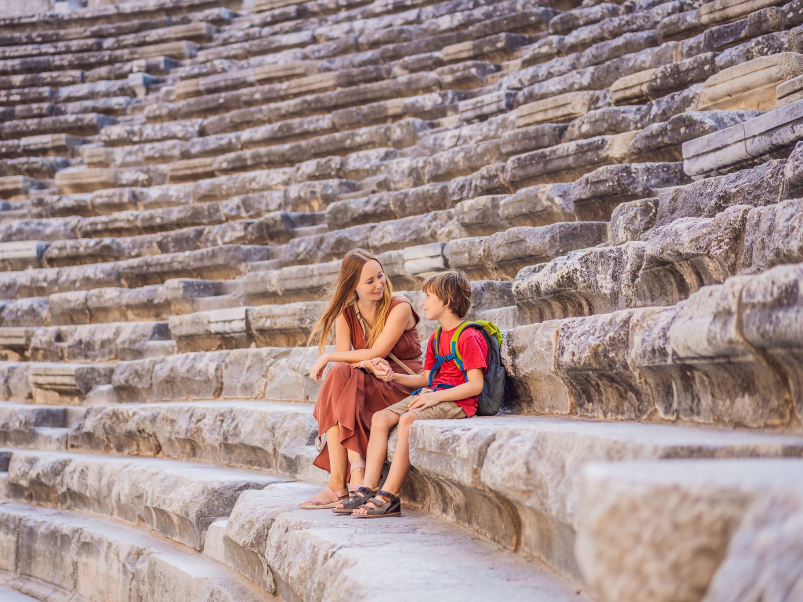 Мама с сыном отдыхают на ступенях древнего амфитеатра в Аспендосе