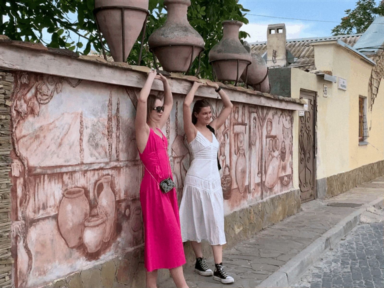 Девушки на фоне городской стены