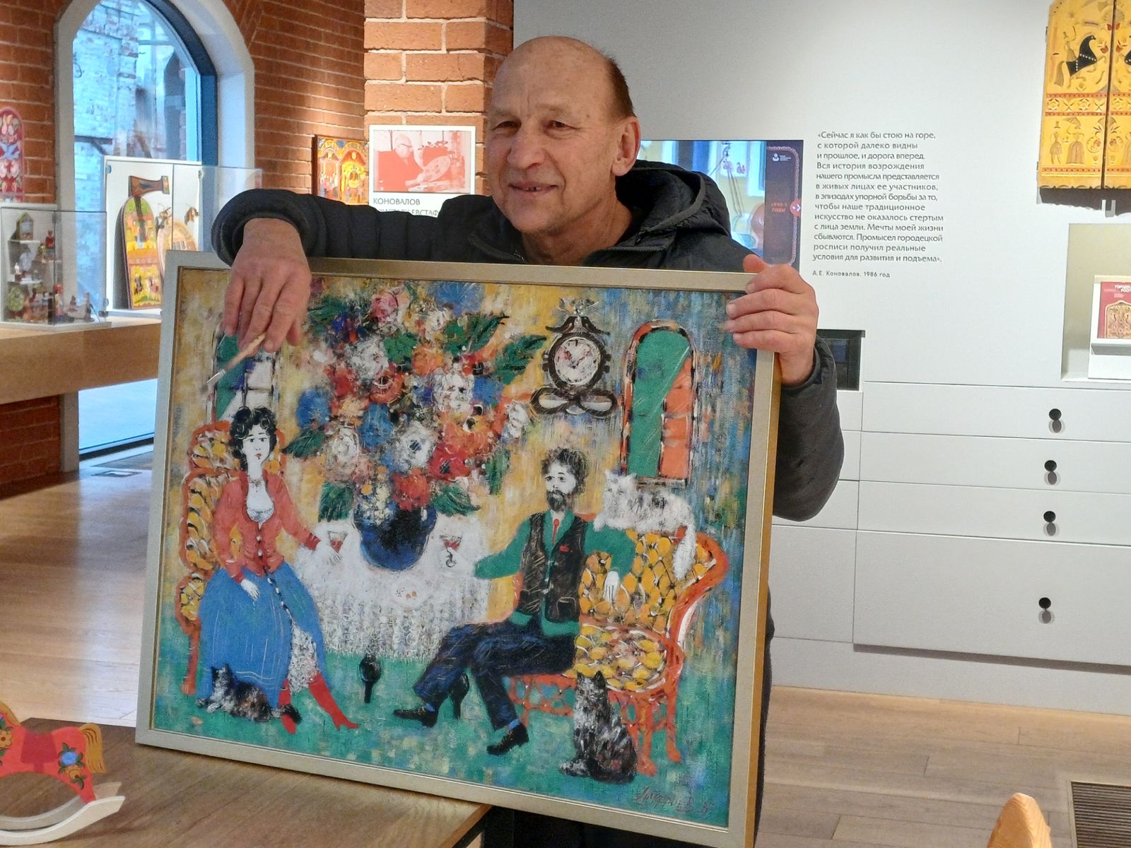 Художник Виктор Ануфриев с картиной на городецкую тему "В гостях" в музее "Городецкая роспись"